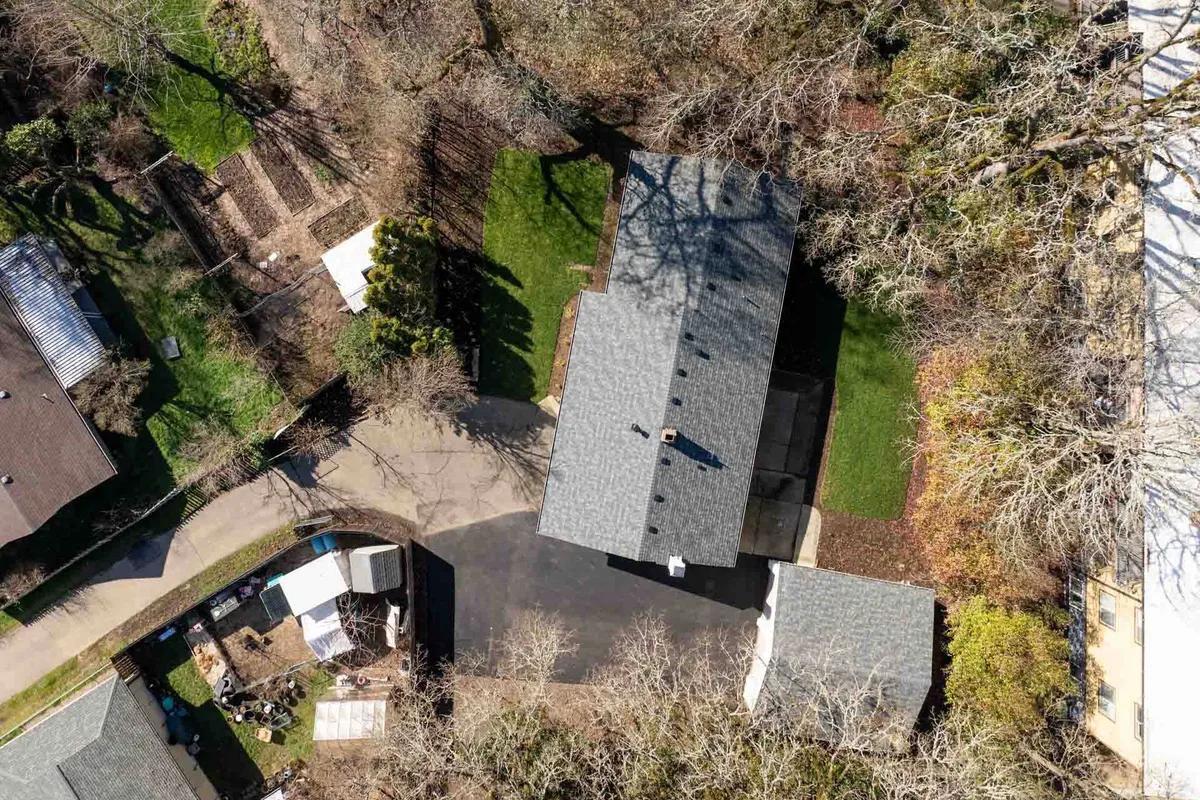 This image features the main house from the backyard, framed by abundant greenery. The backyard area is spacious and inviting, ideal for outdoor relaxation or gatherings, and reflects the peacefulness mentioned in the section.