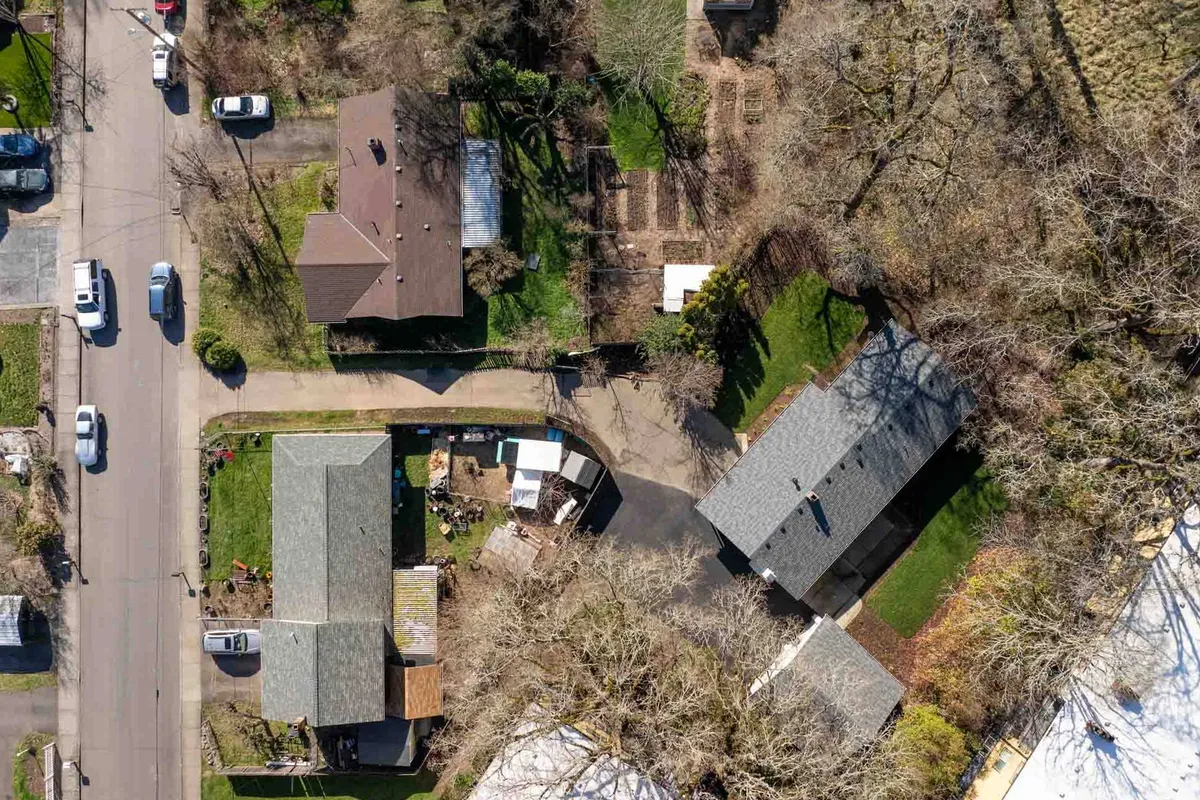 This image captures the exterior of a welcoming residential neighborhood, featuring manicured lawns, rooftops, and mature trees. The scene evokes a sense of community and peacefulness, suggesting easy access to local amenities and the broader Tigard area.
