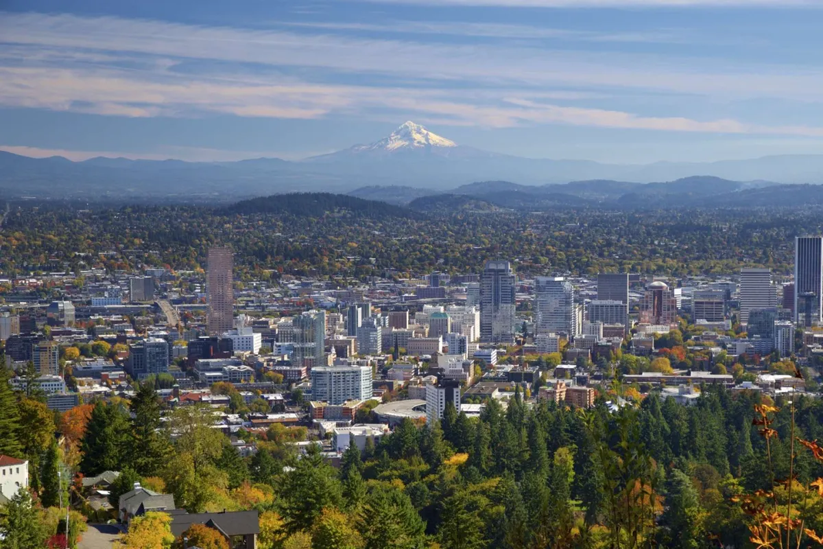 The image showcases a panoramic view of the local area, with the downtown skyline, Mount Hood, and vibrant autumn foliage. It represents nearby attractions and the broader natural beauty surrounding The Holistic Hideaway.