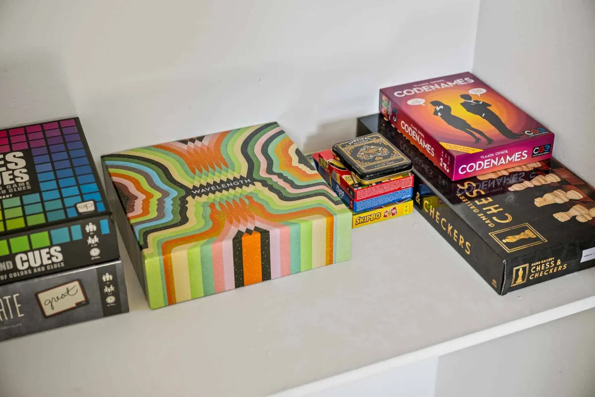 A cheerful interior scene displaying a variety of colorful board game boxes, set out and ready for play. The bright, engaging mood invites families to imagine enjoying game nights together.